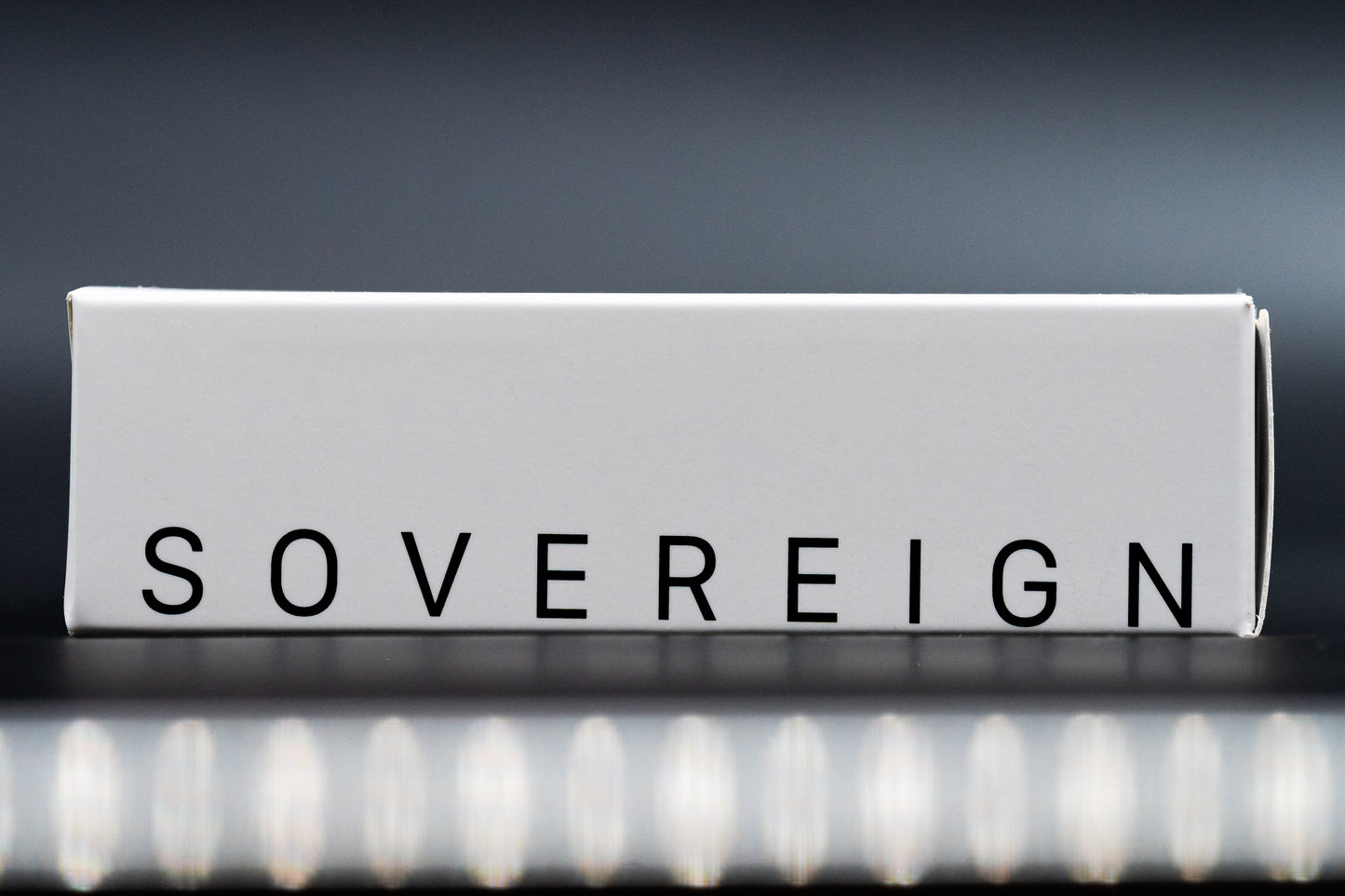 Rolled-up paper with the word 'SOVEREIGN' on a reflective surface with a dark background